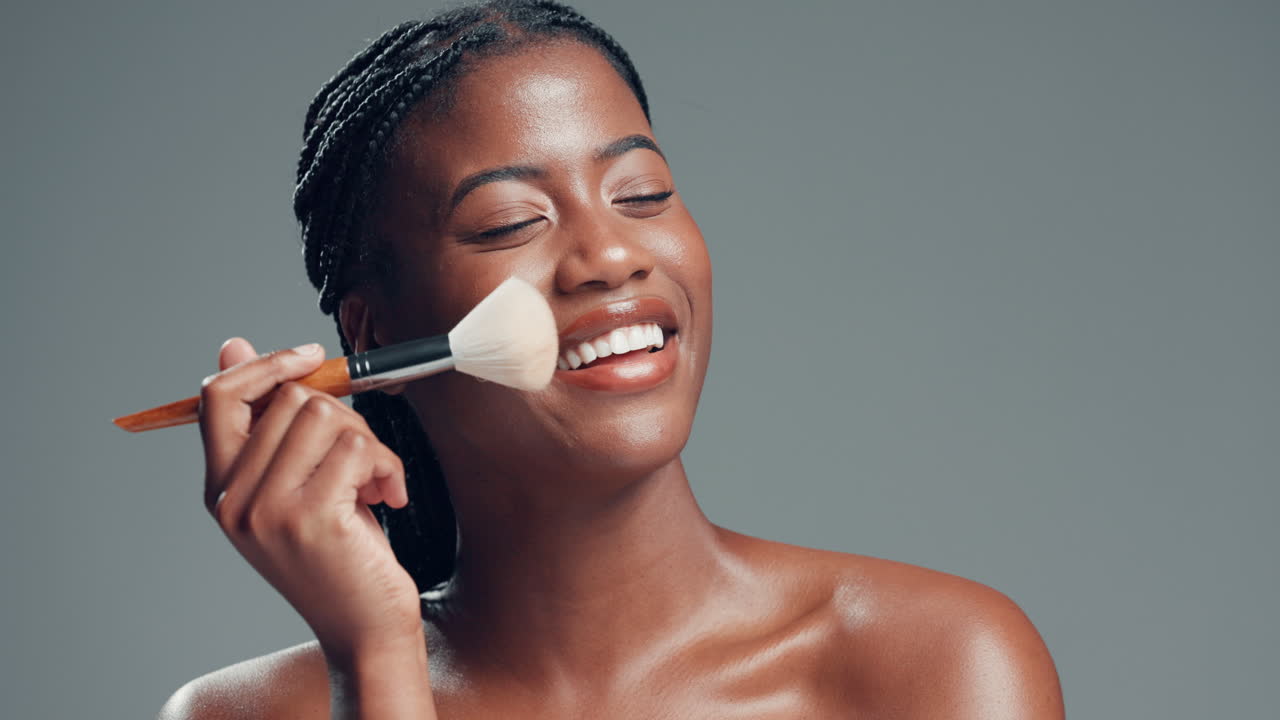 Beautiful woman applying makeup with a brush
