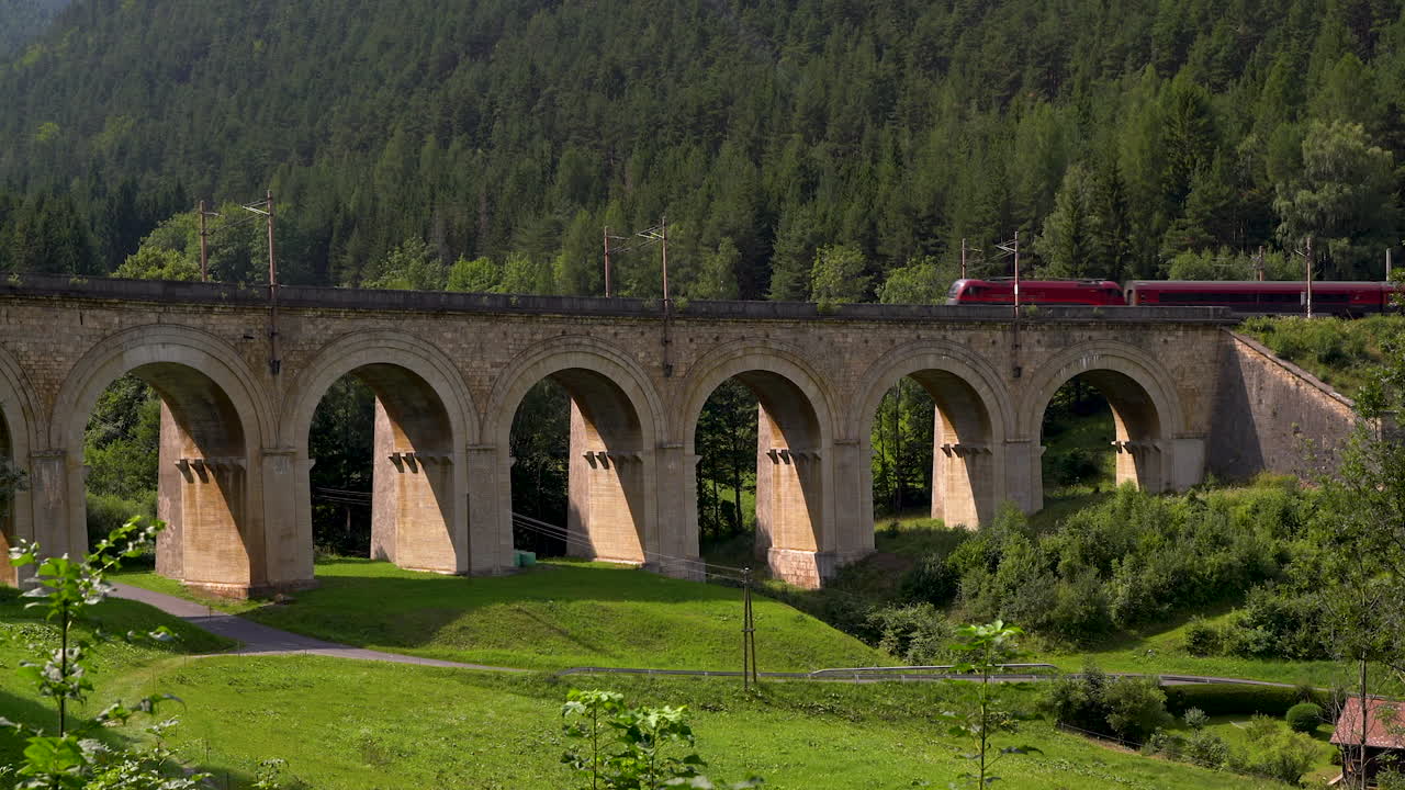 cacerola lenta sobre el puente del viaducto en el ferrocarril semmering con el tren corriendo a través de él
