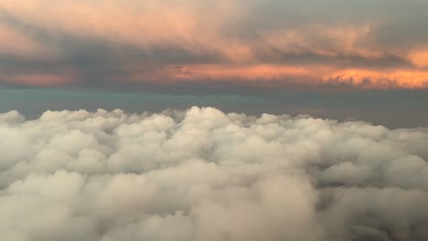 a pilot’s fpv flying among layers of clouds with the early morning light with come clouds illuminated by the sunrise. aerial shot from a jet cockpit. 4k 60fps