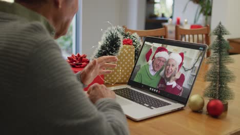 Caucasian-senior-man-having-a-videocall-on-laptop-at-home-during-christmas