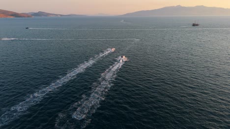 boats speeding across the calm waters near saranda, albania during a peaceful sunset