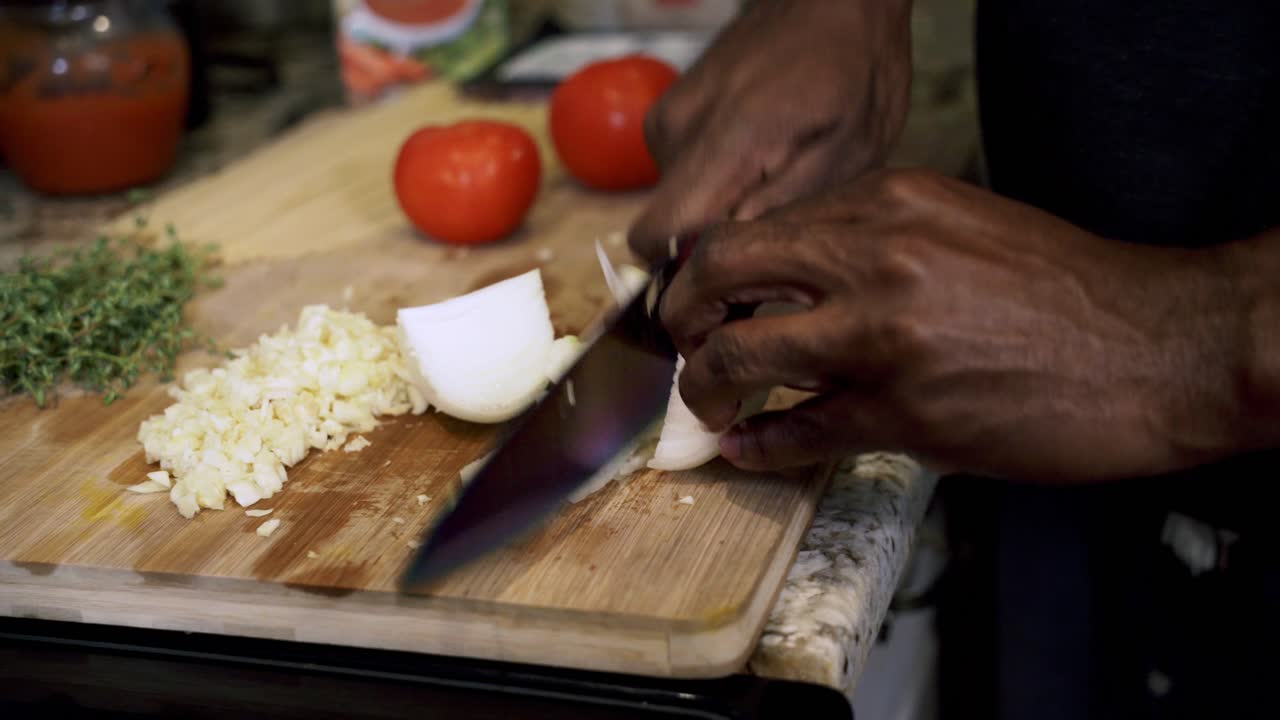 Cutting whole onions Preparing ingredients to make vegan beyond meatballs with spaghetti and meat sauce