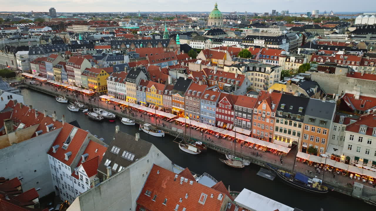 Aerial drone view of the Nyhavn waterfront, canal and entertainment district in Copenhagen, Denmark in the evening