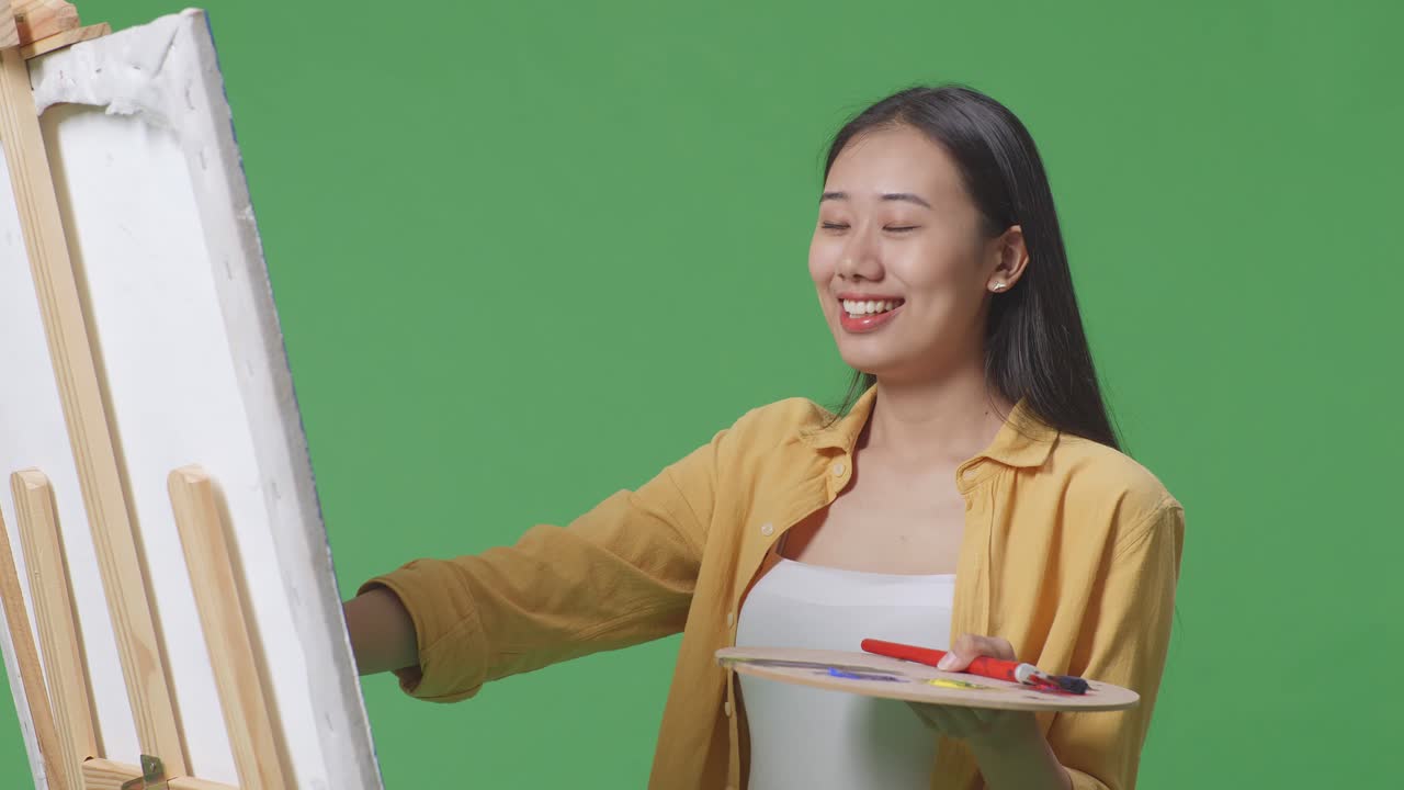 평화의 표지판과 그림을 그리는 물품을 가진 여성 예술가