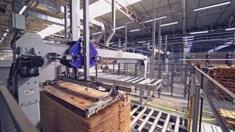 special automatic equipment shifts wooden boards on a pallet in the workshop. woodworking factory.