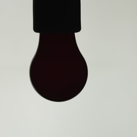The-red-incandescent-lamp-is-turned-on-on-a-white-background