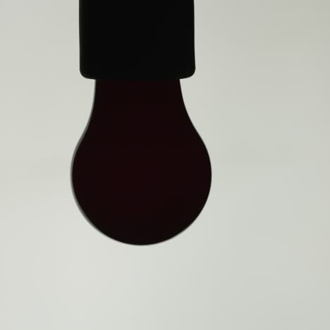 la lámpara incandescente roja está encendida sobre un fondo blanco