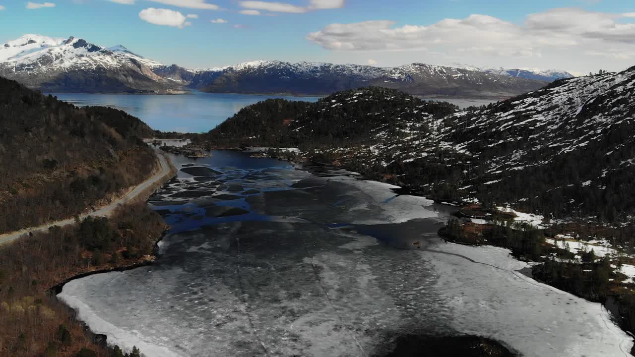 봄 동안 눈 덮인 산이 있는 아름다운 계곡에서 녹는 호수의 슬로우 모션 공중