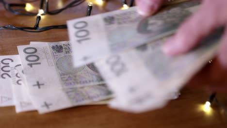 man counts money, polish cash as a christmas gift, close-up, the christmas lights