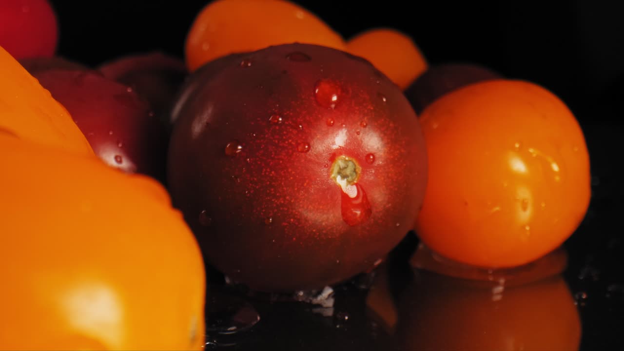 Cinematic macro shot of some red and orange wet cherry tomatoes