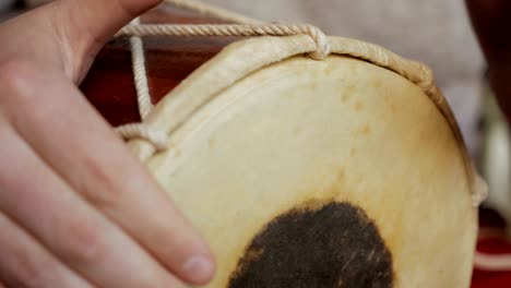 close up of hands of a man playing a drum.