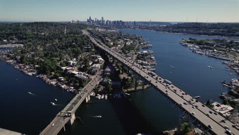 amazing aerial of seattle city with cars crossing bridge and boats cruising lake