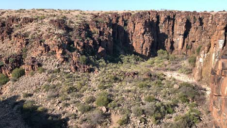 la inclinación hacia arriba revela las paredes del cañón destrozadas de color rojo oxidado en un paisaje árido