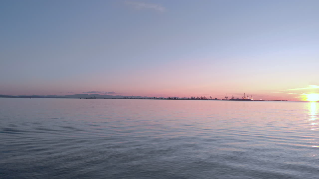 해변에서 이륙하여 바다 위의 일몰 속으로 날아가는 드론의 1인칭 시점