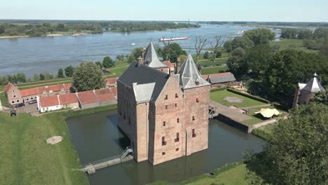 drone flying around monumental castle loevestein near river maas in the netherlands