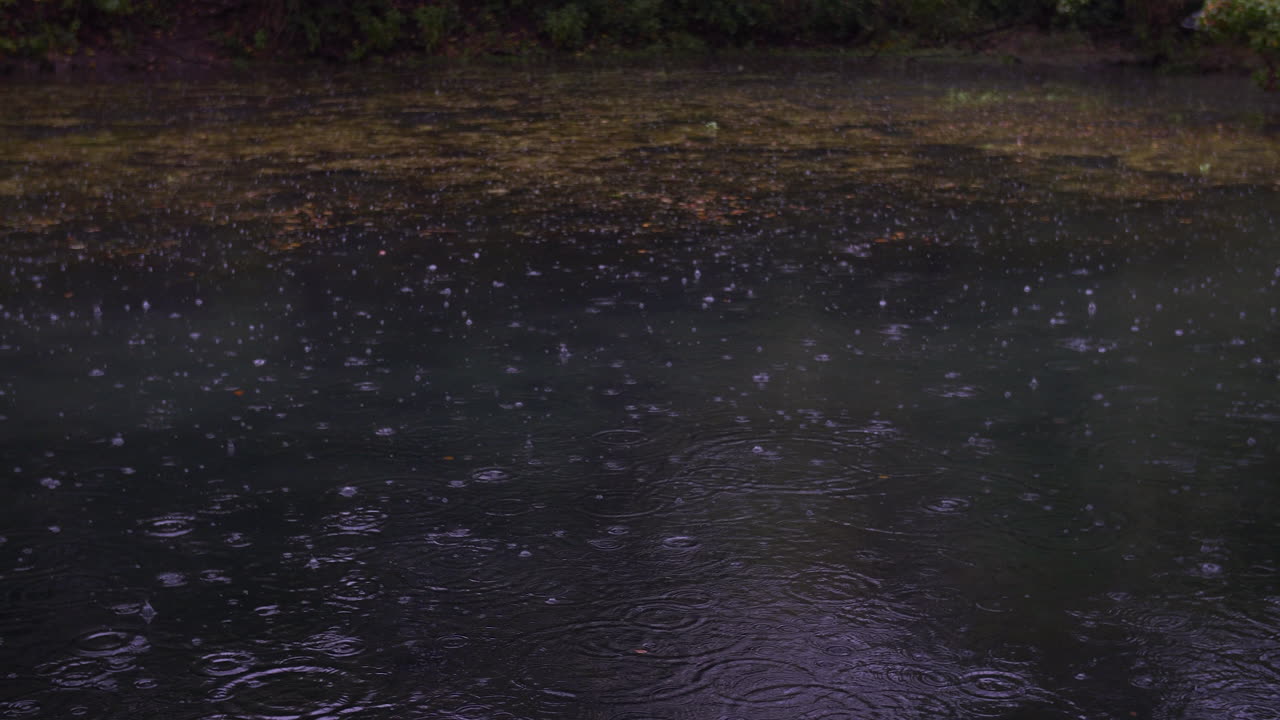 A slow motion shot of rain drops hitting a river