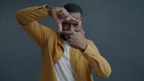 man posing with fingers framing face