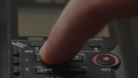 close up of voice recorder being stopped by pressing on the stop button