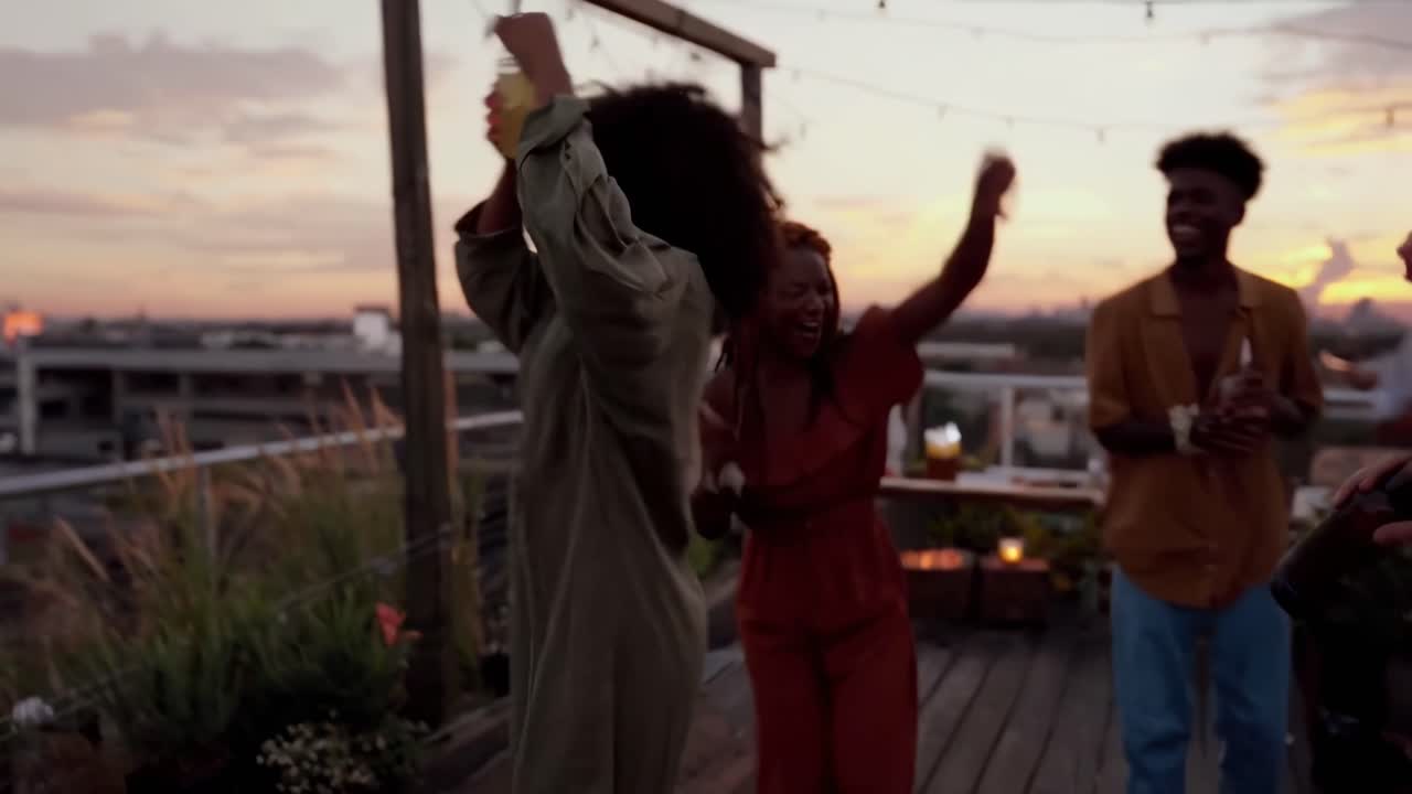 Video of friends celebrating at sunset, captured from a low angle for a lively feel
