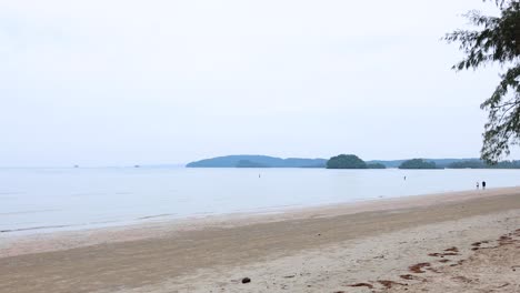 people strolling on a serene beach in krabi