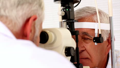 doctor examining eyes of elderly patient
