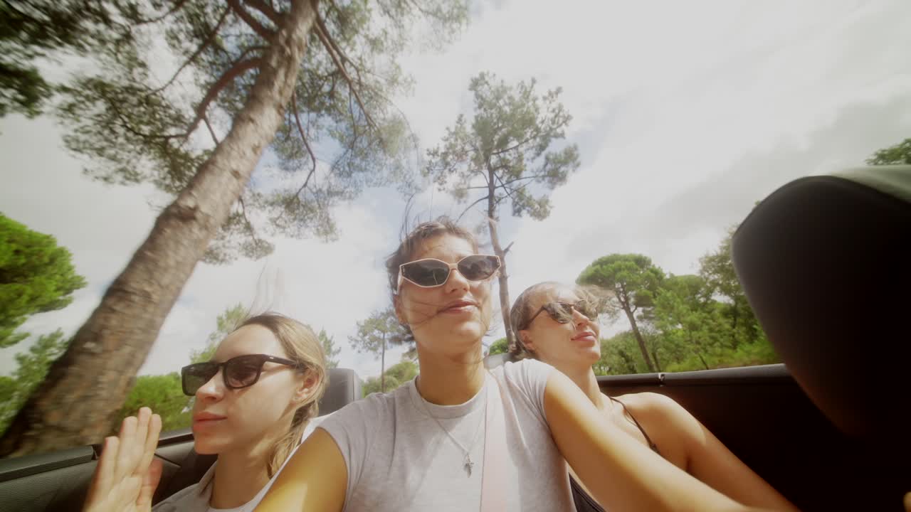 Three Women Enjoying a Road Trip in a Convertible
