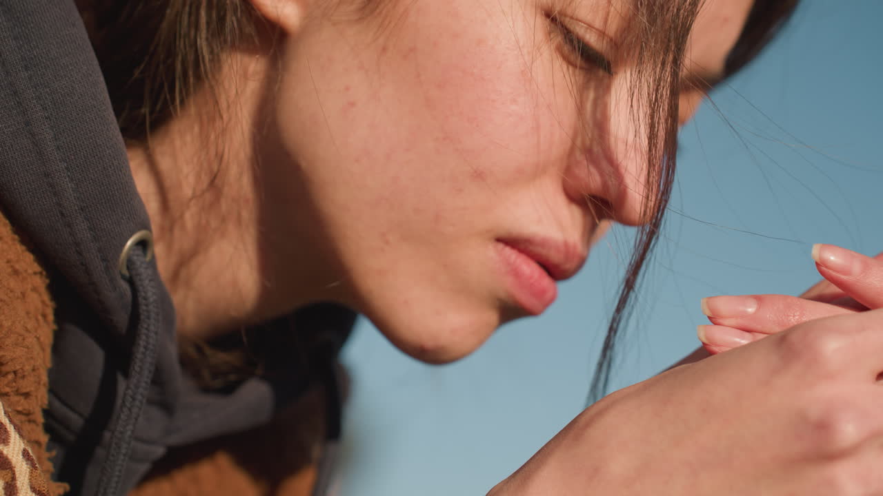 갈색 코트를 입은 소녀의 클로즈업, 그녀의 머리는 그녀의 손에 기대어, 그녀의 표정은 깊이 불행하고, 슬과 숙고의 느낌을 반영합니다.