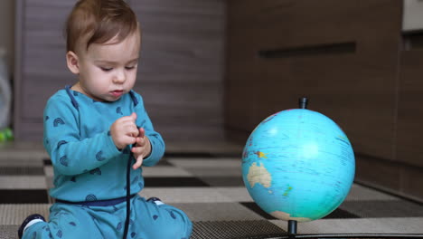 baby exploring a globe