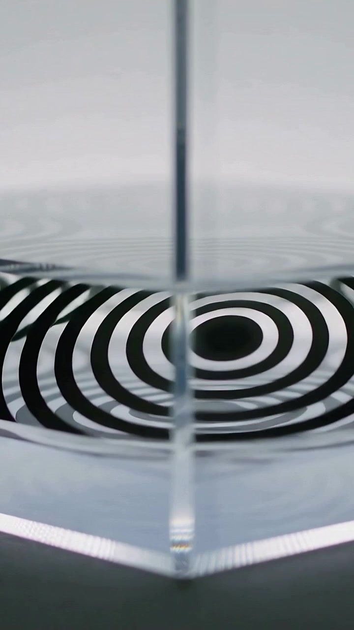 Vertical video: Droplet hitting rim, water forming waves under glass panel in studio warping rings