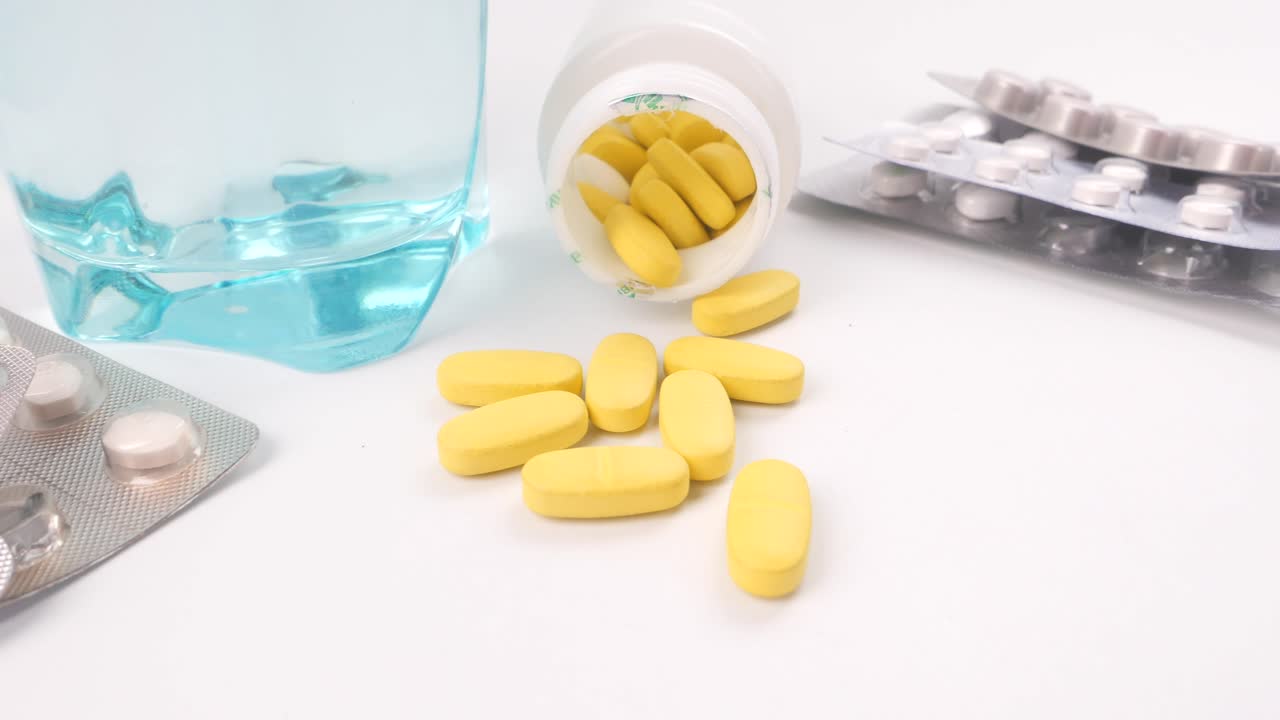 Pil kuning dengan air dan kemasan obat lainnya