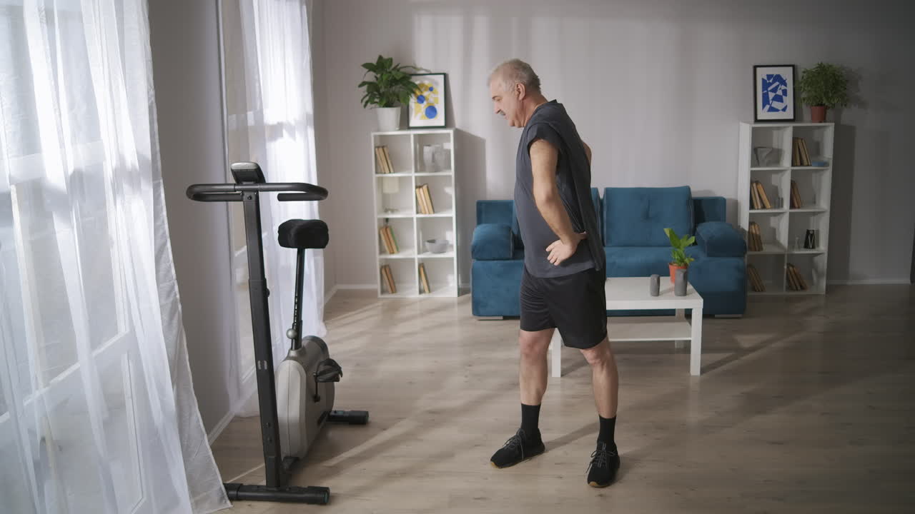 gimnasia para la prevención de la osteocondrosis hombre de mediana edad está entrenando solo el domingo por la mañana calentando músculos y articulaciones