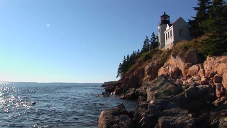 a lighthouse on the edge of a cliff overlooking the ocean in bass harbor lighthouse maine