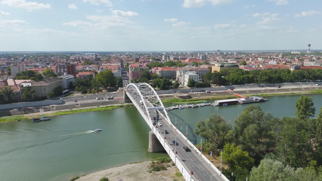 Beautiful drone flight over Szeged’s Belvárosi Bridge, emphasizing its connection between city districts and the shimmering Tisza River below