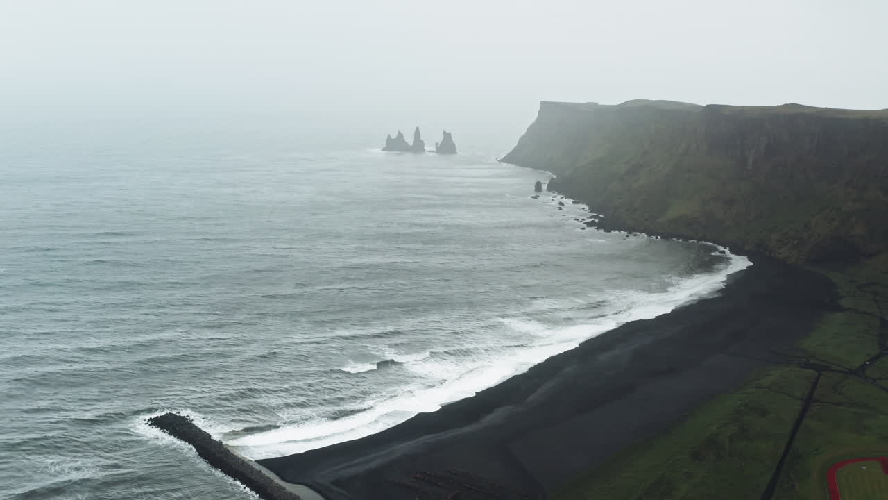Aerial Drone view over Black Sand Beach in V&iacute;k &iacute; M&yacute;rdal - Iceland Dramatic misty view over Icelandic Coastline