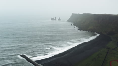 Aerial-Drone-view-over-Black-Sand-Beach-in-Vík-í-Mýrdal---Iceland-Dramatic-misty-view-over-Icelandic-Coastline