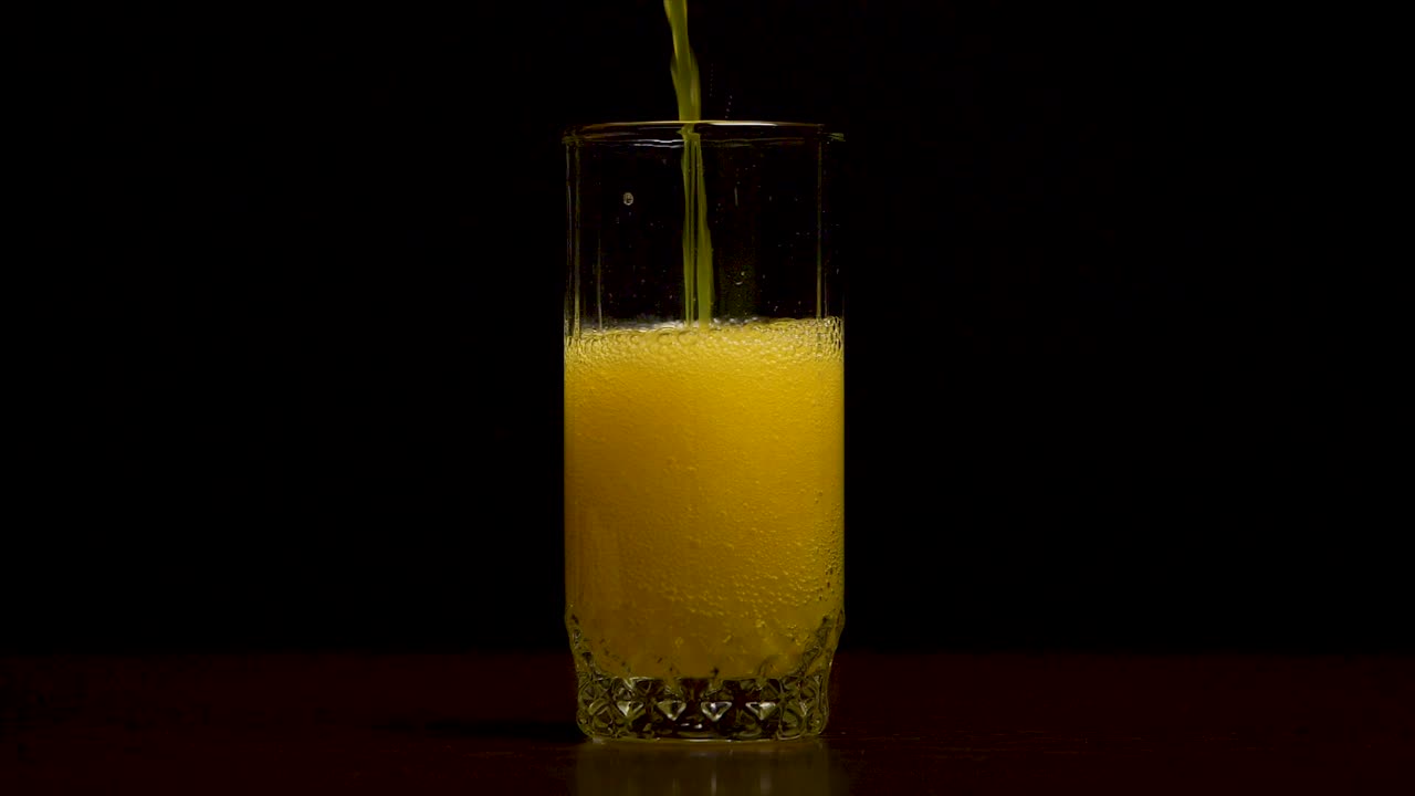 Versamento di aranciata in un bicchiere