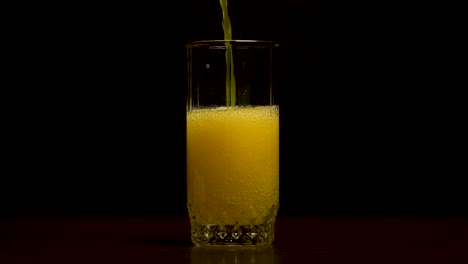 pouring orange soda into a glass