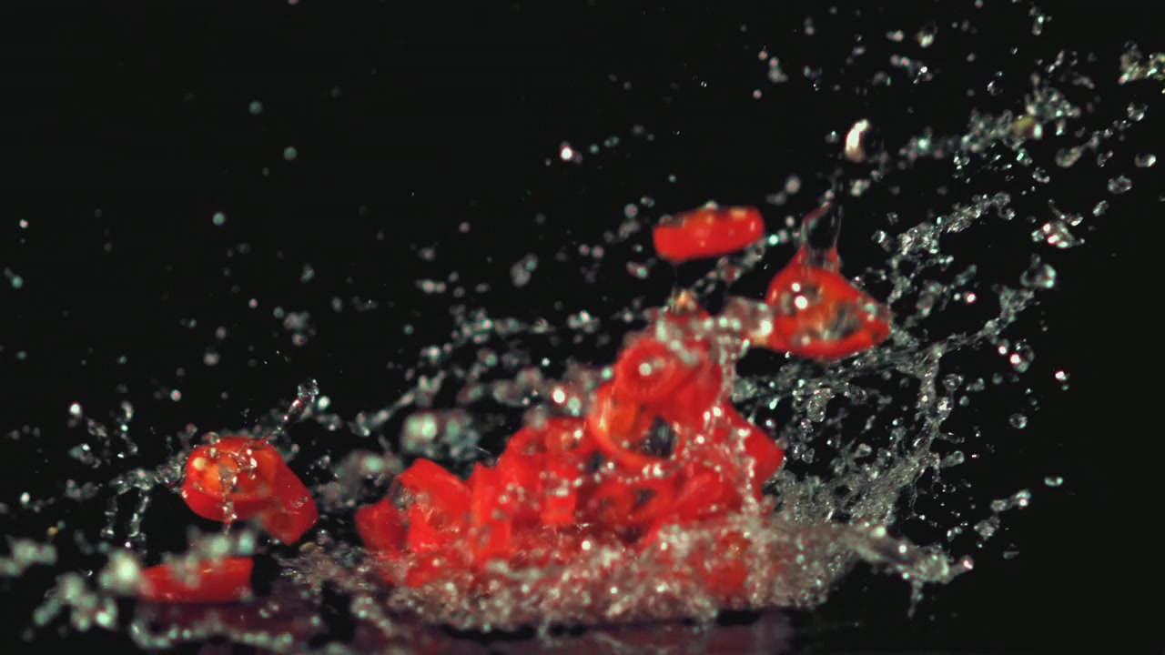 Fresh Red Chili Pepper Slices Splashing in Water