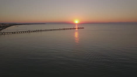 Flying-over-sea-and-pier-at-sunset