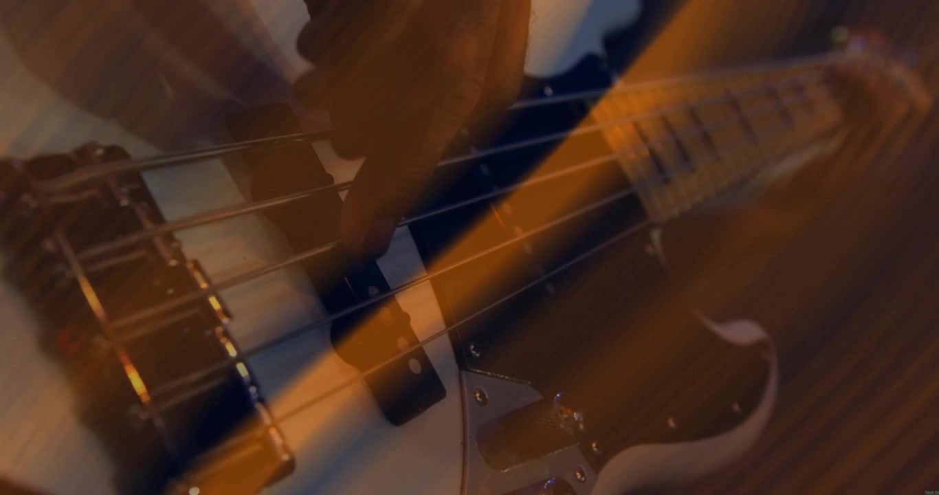 Male guitarist starting music riff as orange wave overlay sweeping across shot showing pickups