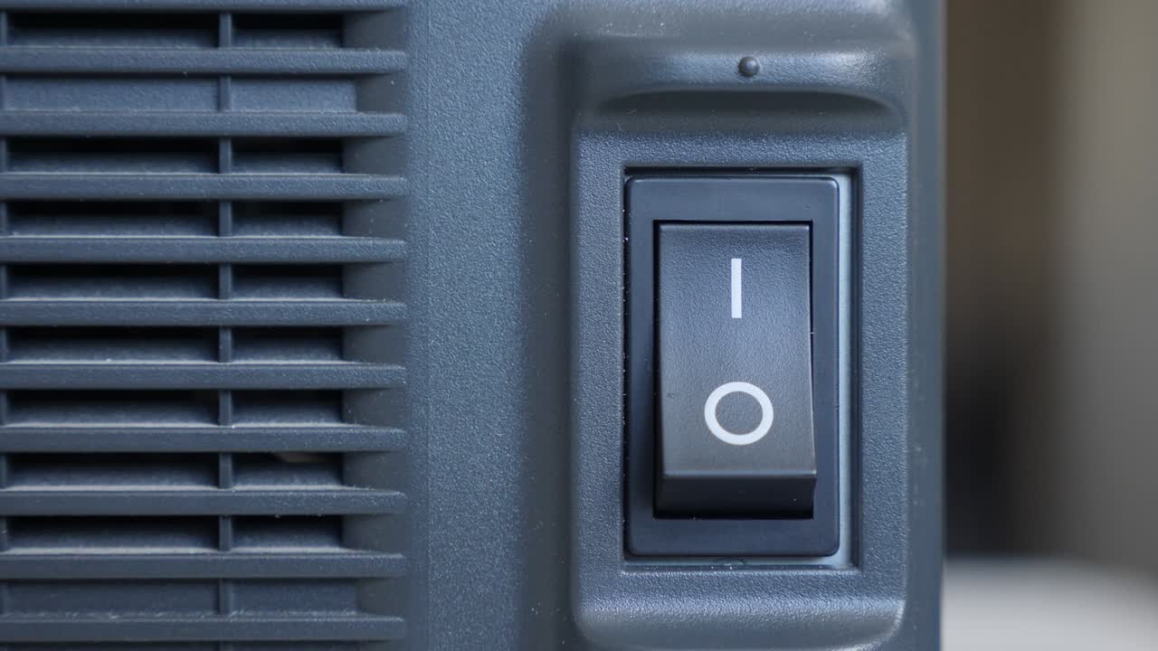 палец человека нажимает и выключает черную пластиковую кнопку