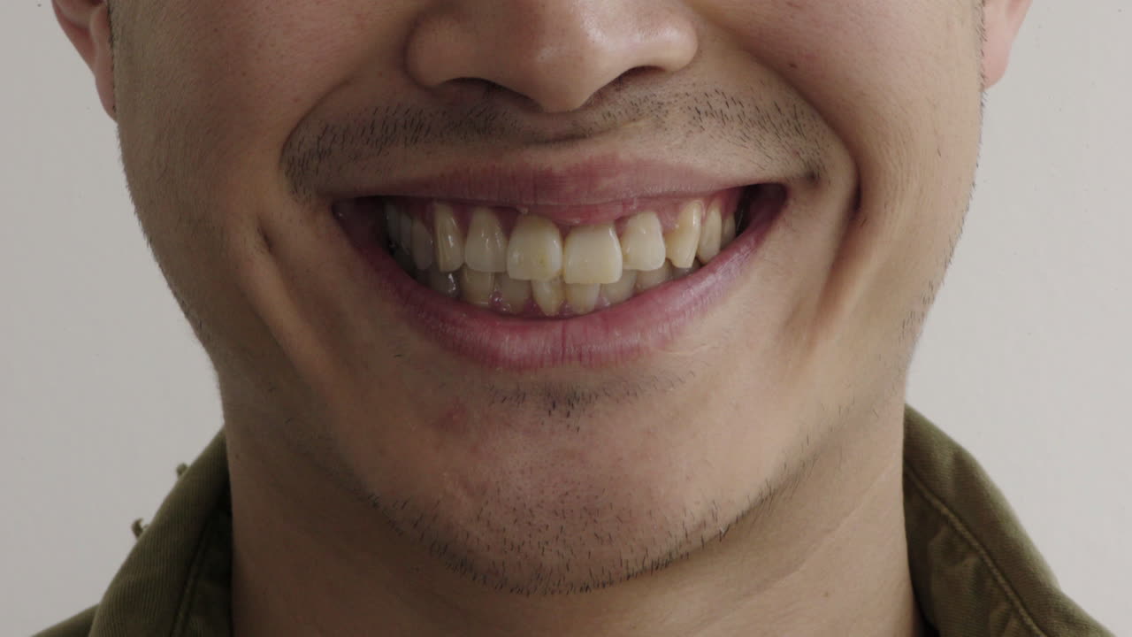 cerrar los labios del joven sonriendo alegremente feliz mostrando los dientes concepto de salud dental