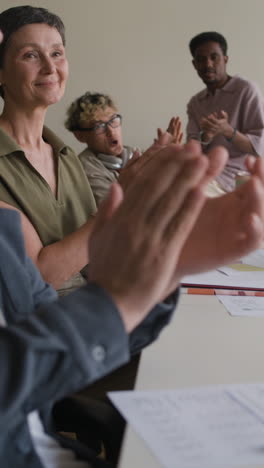 group of diverse people clapping and applauding in a business meeting or presentation