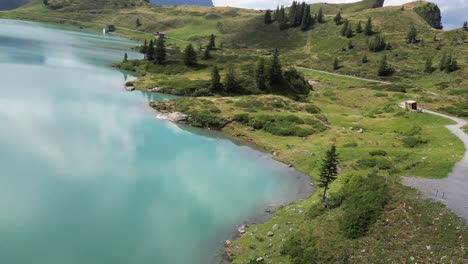 vista de drone fpv de un lago alpino con agua azul brillante en los alpes suizos, reflejo de nubes en la superficie, obwalden, engelberg