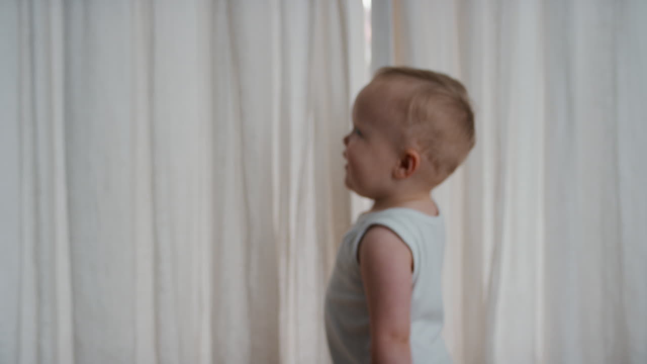 смешной ребенок играет в укрытие за шторами счастливый малыш весело играет в прятки наслаждается детским весельем дома 4k