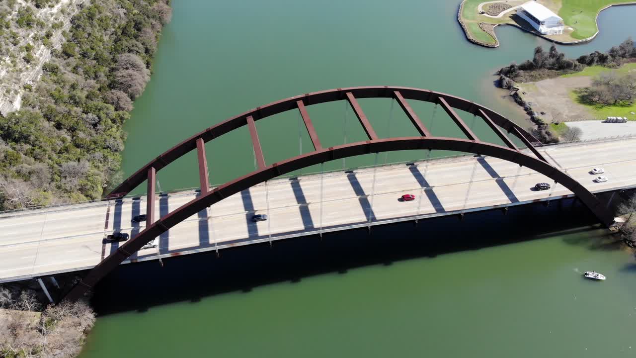 Aerial Austin Pennybacker Bridge - static shot of the bridge at medium altitude, bridge and river filling the frame with no sky included. Boat in bottom corner having just been launched