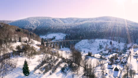 winter mountain countryside with a railway viaduct in falling snow