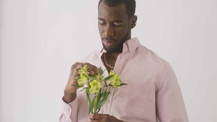 Handsome Guy Smelling And Touching The Flowers On His Hand