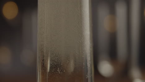 studio product shot of champagne glass with bubbles going up and nice blurred background