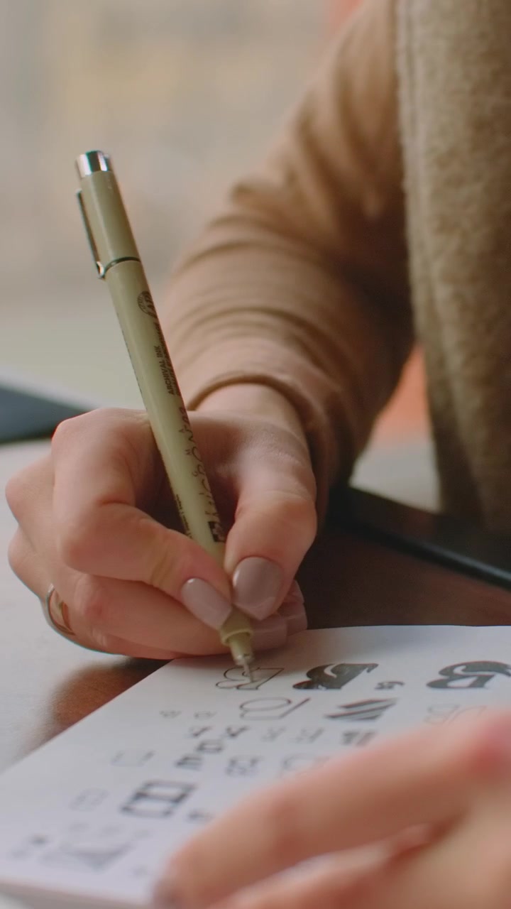 Young Woman Drawing and Sketching in a Notebook
